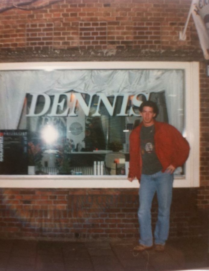Oude foto van een etalage met de naam DENNIS in grote letters op het raam