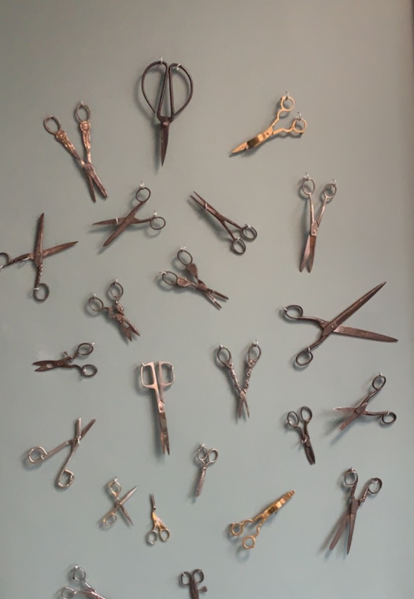 De wand in de salon met een verzameling oude scharen